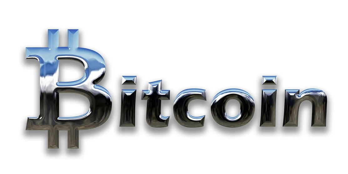 The word "Bitcoin" in reflective metallic lettering on a white background