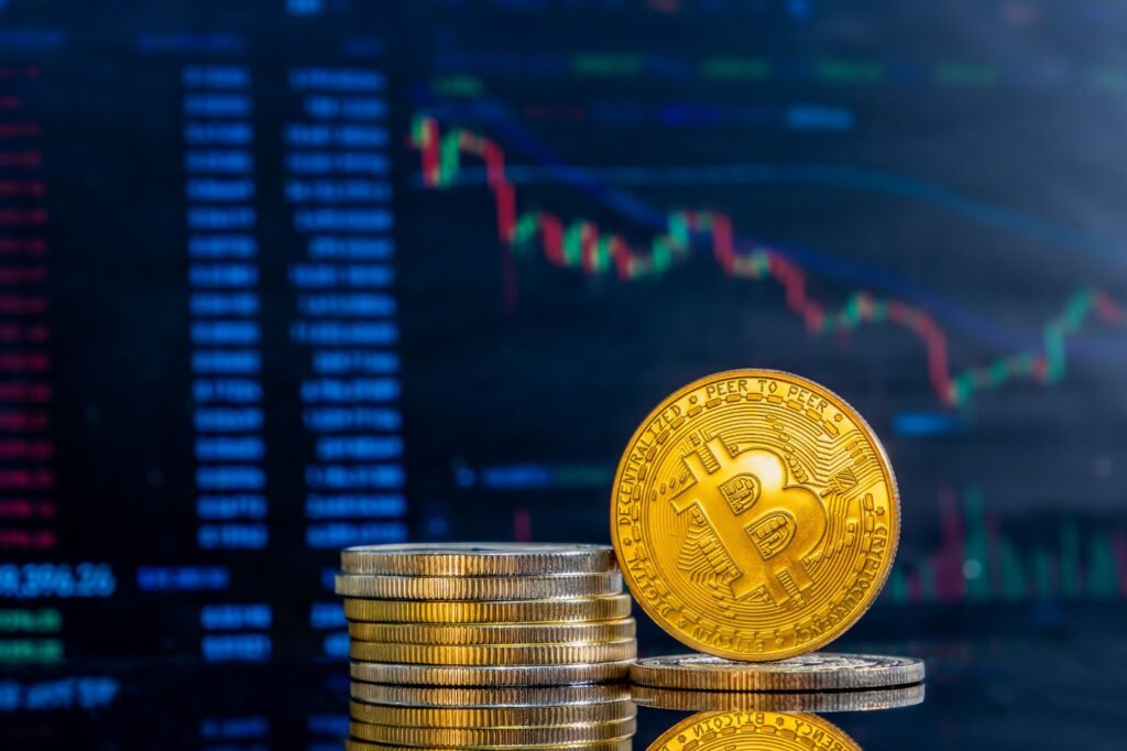 Close up of golden bitcoins on a background of histogram of decreasing crypto